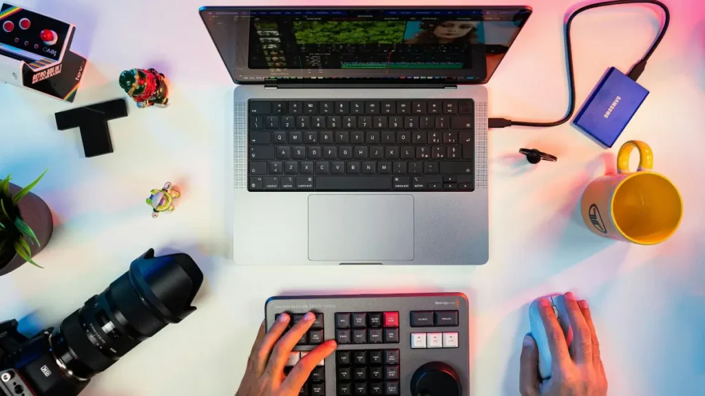 Freelance video editor using editing tools on a laptop with camera on the table